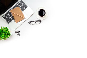 White office desk table with blank notebook, computer keyboard and other office supplies. Top view with copy space, flat lay.