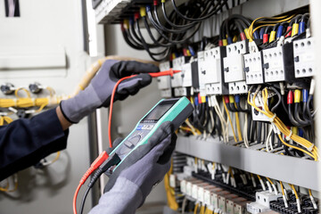 Electrician engineer tests electrical installations and wires on relay protection system....