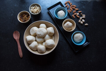 Sweet item rasgulla or dry rosogolla in a bowl on a dark background. Top view.