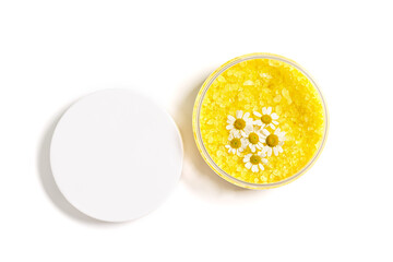 Bath salt sea with herbal extract of chamomile, sea salt crystals in open jar with cap isolated on white background. Close up body care cosmetic, natural organic spa product, herbal medicine