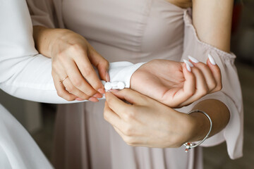Obraz na płótnie Canvas Woman helps bride to fix her sleeve covered