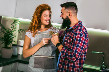 Young couple in love drinking wine in house kitchen