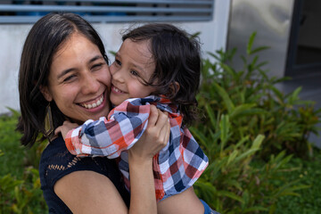 Mom and her Latin American son show their love with hugs and smiles. Mother's day concept and family