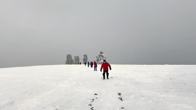 A group of tourists near the giants of the Manpupuner Plateau, Komi Republic, Russia. Weathering pillars. Geological monument in the Troitsko-Pechora region. One of the seven wonders of Russia.