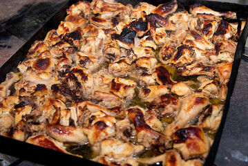 chicken cooking. slices of meat on a baking sheet