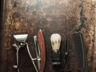 Fototapeta na wymiar vintage barber tools: dangerous razor, hairdressing scissors, old manual clipper, comb, shaving brush