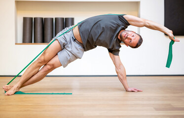 Fit muscular man doing a resistance band exercise