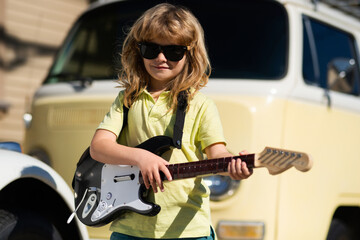 Kids musical instruments. Child musician guitarist playing electric guitar.