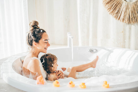 Mother and child having bubble bath.