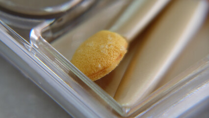 Close up of an old eye shadow sponge applicator that should be thrown away.
