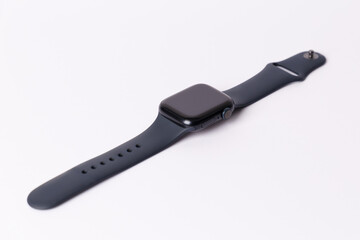 A smartwatch isolated on a white background. Black smartwatch with insulated wrist with open strap. Modern design for high-tech smartwatch and sport technology concept. Close up. Top side view.