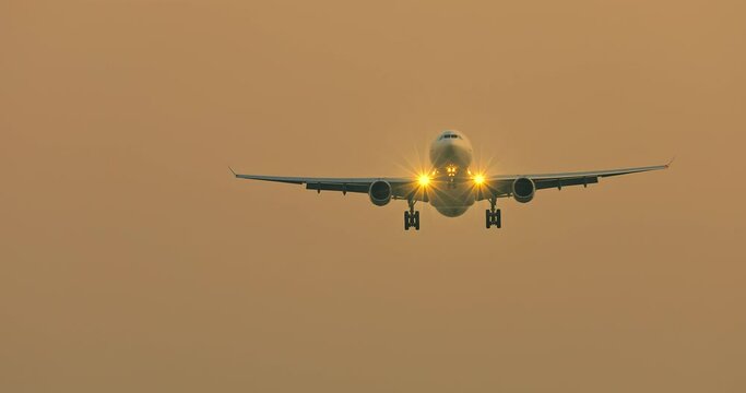 Airplane preparing to land over the airport at sunset. travel concept. 4K real time footage.
