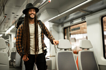 Young man using digital tablet while traveling by a train. Handsome young man traveling by a train.