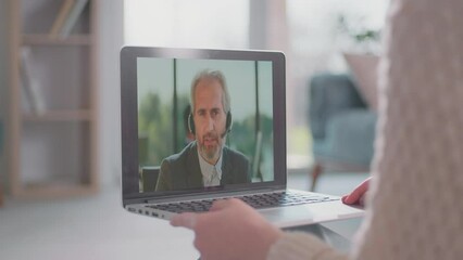 Young woman doing video consultation with skilled male teacher at home