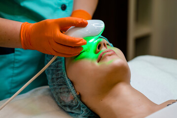 Elos epilation hair removal procedure on the face of a woman. Beautician doing laser rejuvenation...