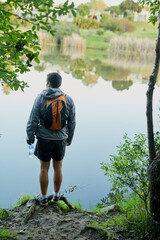 The views out here are unreal. Rearview shot of a young male athlete taking in the lake views while hiking in the forest.