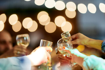 clink glasses of champagne close-up with beautiful lights
