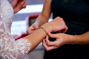Obraz na płótnie Canvas gold bracelet and wedding manicure hands