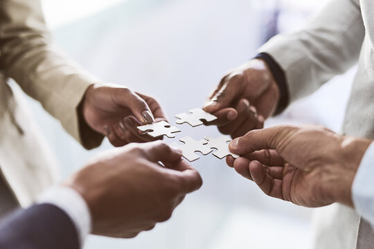 Do You See The Bigger Picture. Closeup Shot Of A Group Of Unrecognizable Businesspeople Joining Puzzle Pieces Together In An Office.