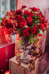 red floral arrangement in a vase of roses and carnations
