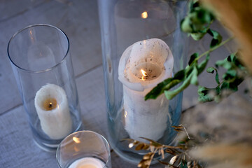 burning candles in vases in glass boxes floristry gold