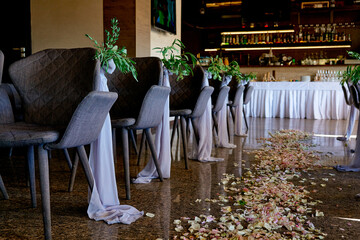 path of rose petals at a wedding among chairs at a ceremony
