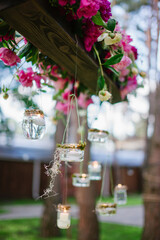 burning candles on a hanger decoration with floristry