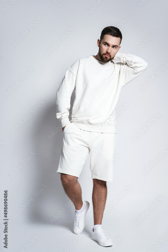 Wall mural Handsome man wearing white sweatshirt and shorts