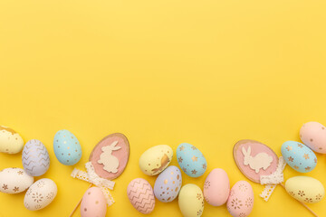 Fototapeta na wymiar Easter colorful eggs on a yellow background with copy space. Top view. Easter card