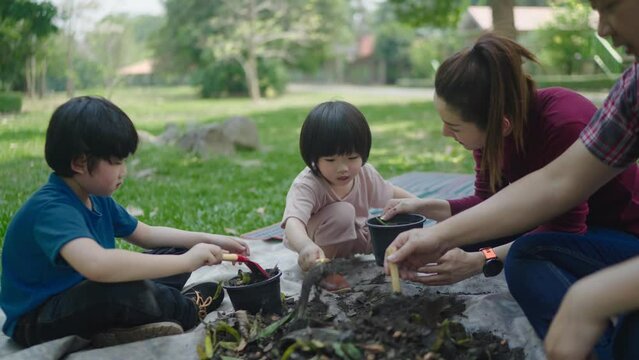 A family of two sons is helping carry out scraps of fruits and vegetables to learn how to make natural compost. In the front garden on holidays