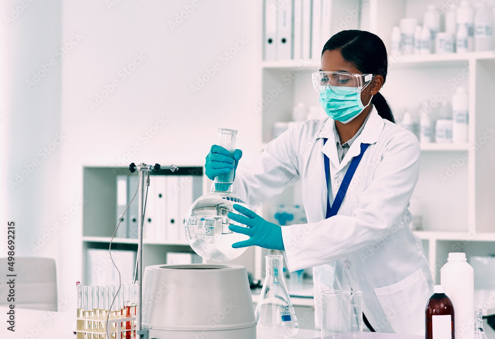 Poster Shes got an experiment to do. Cropped shot of an attractive young female scientist placing a florence flask with a liquid into a centrifuge while working in a laboratory.