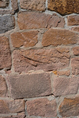 Pattern of ancient bricks and stones at old middle age wall, as a background, closeup, details.