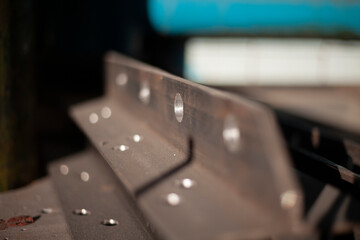 Holes in steel from drilling. Metal blank. Steel profile is drilled with drill in workshop. Iron product.