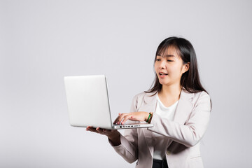 Woman smiling confident smiling holding using laptop computer and typing keyboard for online sending email or chat, Portrait excited happy Asian young female studio shot isolated on white background