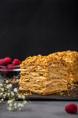 Napoleon cake with raspberries on the black background. Slice cake of puff pastry with raspberry on a black marble plate. Beautiful composition of a piece of delicious dessert. Copyspace.
