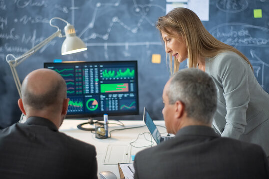Business team planning new investments. Two serious man and woman focused on analyzing market currency data to work out business strategy and plans. Business startup, investment activity concept