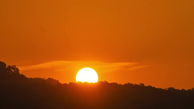Timelapse of dramatic sunset with orange sky in a sunny day.