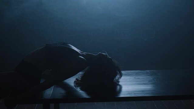 Silhouette of a sexy girl dancing an erotic sensual dance in blue smoke.