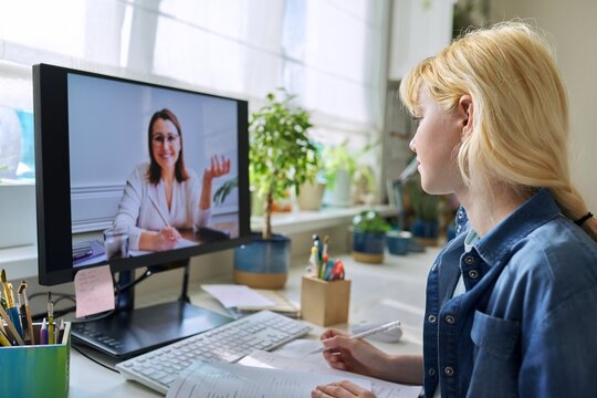 Teenage girl studying at home online using computer