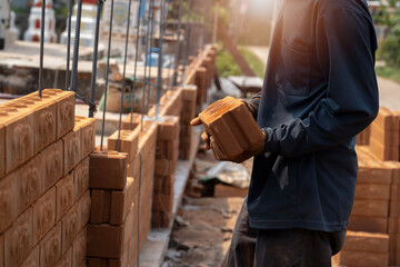 Builder carefully puts red brick on the masonry. Quick work bricklayer. Guy measures level masonry....