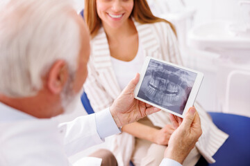 Obraz premium Woman at dental clinic consulting with dentist