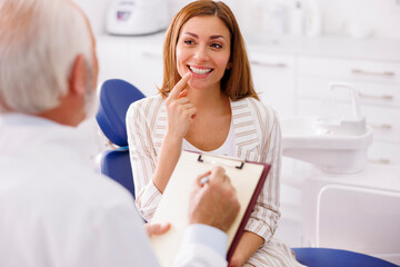 Obraz na płótnie Canvas Dentist taking medical records from patient