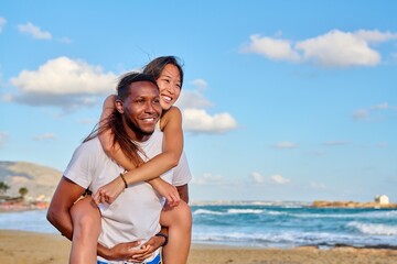 Happy young beautiful couple having fun on the beach, copy space