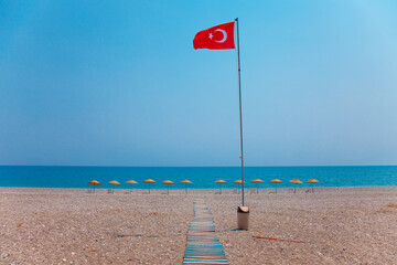Red turkish national flag on empty sea beach