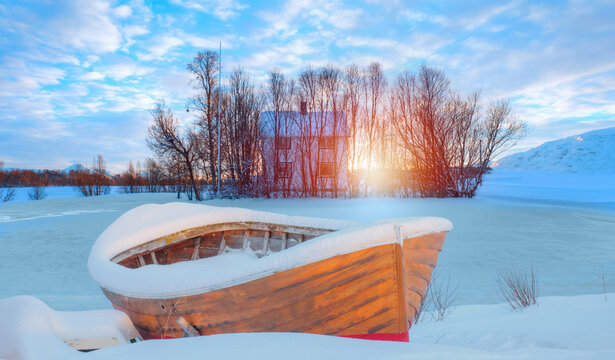 Red wooden boat covered snow - Beautiful winter landscape with red house and red cabin - Arctic city of Tromso, Norway