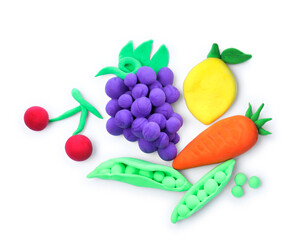 Different fruits and vegetables made from play dough on white background, top view