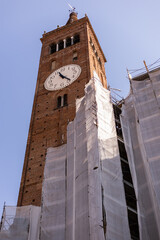 a brick tall old clock tower in italy city