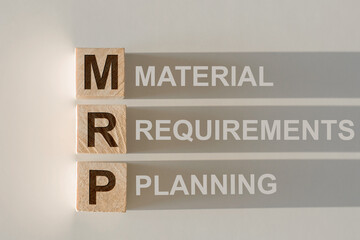 Wooden cubes build the word MRP - abbreviation of Material Requirements Planning on light gray...
