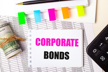 On a light background, a pen, dollars, a notebook with the text CORPORATE BONDS and bright stickers. Business concept