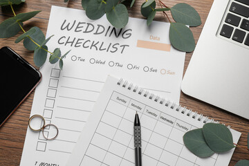 Flat lay composition with Wedding Checklist and calendar on wooden table